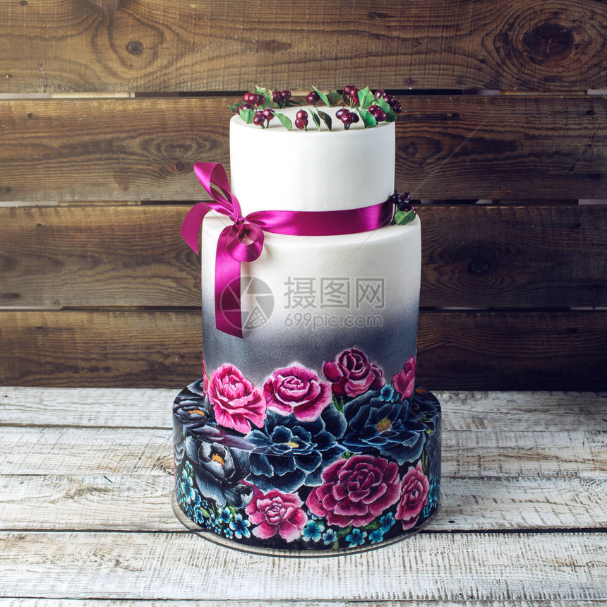 大型婚礼蛋糕装饰在传统的生锈风格的蓝色和紫色玫瑰以及带子中图片