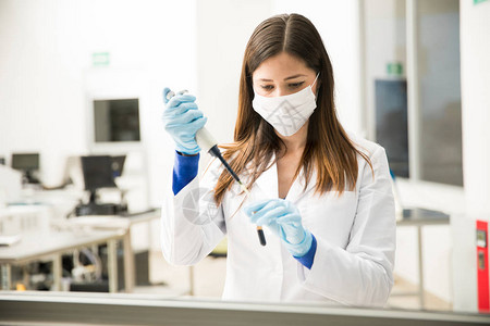 美貌女化学家使用管子来准备血液样本供实验室测试单位图片
