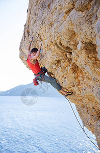 年轻人带领攀登海上悬垂的悬崖图片