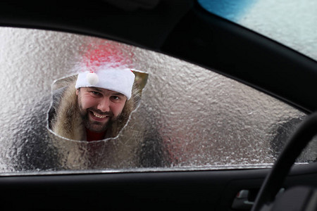 在一辆玻璃破碎的车里穿着圣诞老人红帽图片