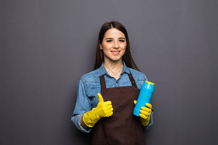 微笑的女人拿着一瓶化学剂用来打扫屋子图片