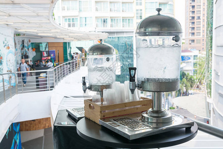 用于会议研讨会或议室的带冰和塑料杯的饮水机作为图片