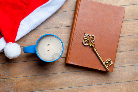 咖啡金钥匙书和圣塔卡帽放在美丽的棕图片