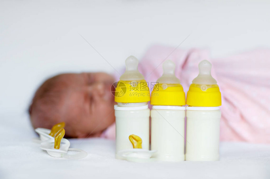 可爱的新生女婴与奶瓶和奶嘴婴儿配方奶粉新出生的孩子图片