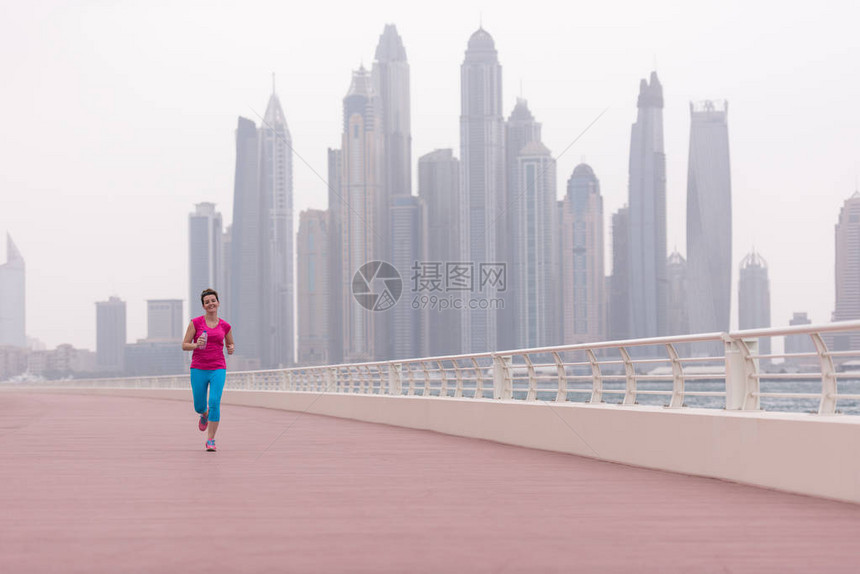 非常活跃的年轻美女忙着在海边的长廊上奔跑图片