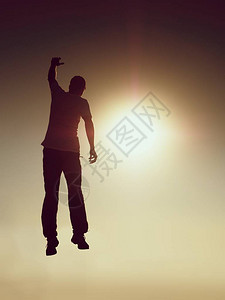 跳跃的人年轻的疯子在红色的天空背景上跳跃跳跃的人和美丽的日落天空的剪影设计元背景图片