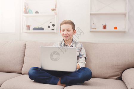 男孩在家里玩电脑很开心儿童和互联网图片