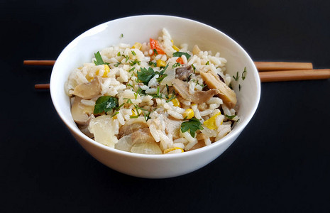 用筷子在黑色蔬菜上的混合米饭碗图片