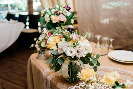 黄色白色和粉红色玫瑰的婚礼花束装在餐图片