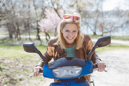 骑摩托车的快乐年轻女人图片