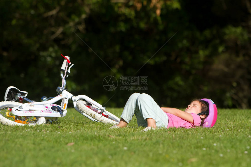 在自然背景下在自行车附近睡觉的幼女天图片