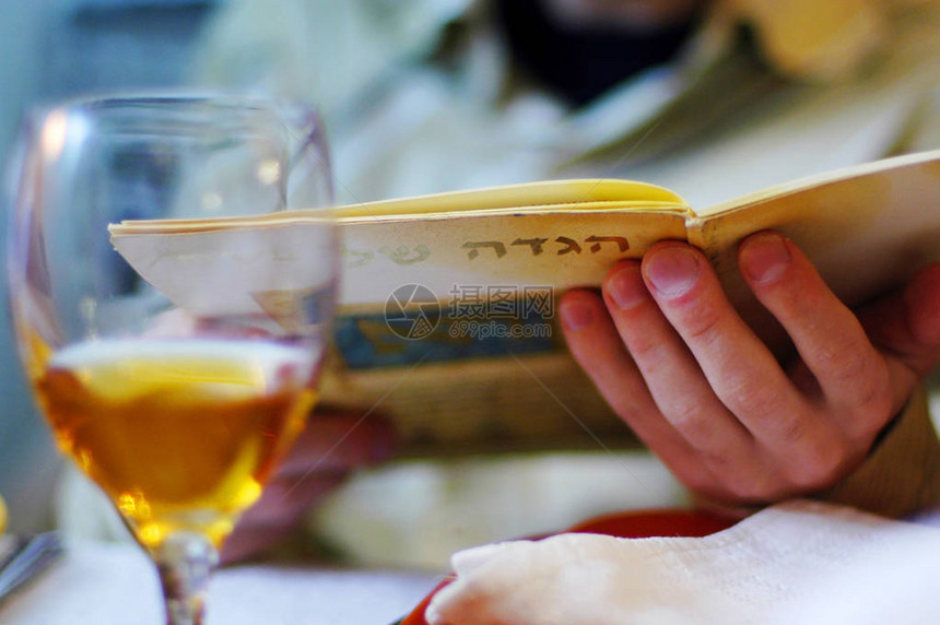 一名犹太男子在犹太人逾越节餐日的祝福期间读了Haggadah图片