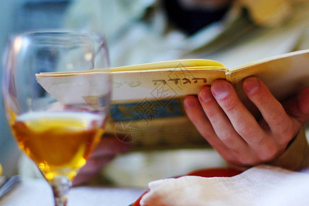 一名犹太男子在犹太人逾越节餐日的祝福期间读了Haggadah图片