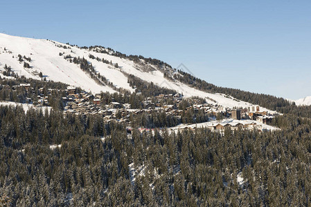 白雪覆盖的高山村庄滑雪胜地的全景与针叶松树图片