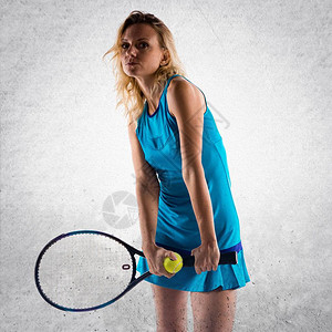 在纹理背景上打网球的金发女郎图片