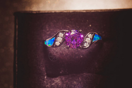 时装黑金色戒指有紫色护身符在闪图片