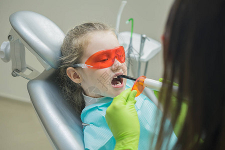 牙科医生在为小女病人补牙之前先图片