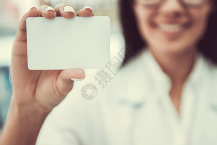 年轻女药剂师持有卡片微笑专注的卡图片