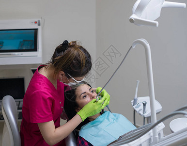 女牙医在牙科诊所为一位美容病图片