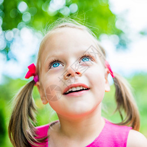 快乐可爱笑童女孩的夏日肖像抬头浅景深图片