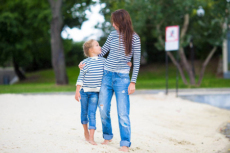年轻母亲和她可爱的小女孩喜欢湖边散图片