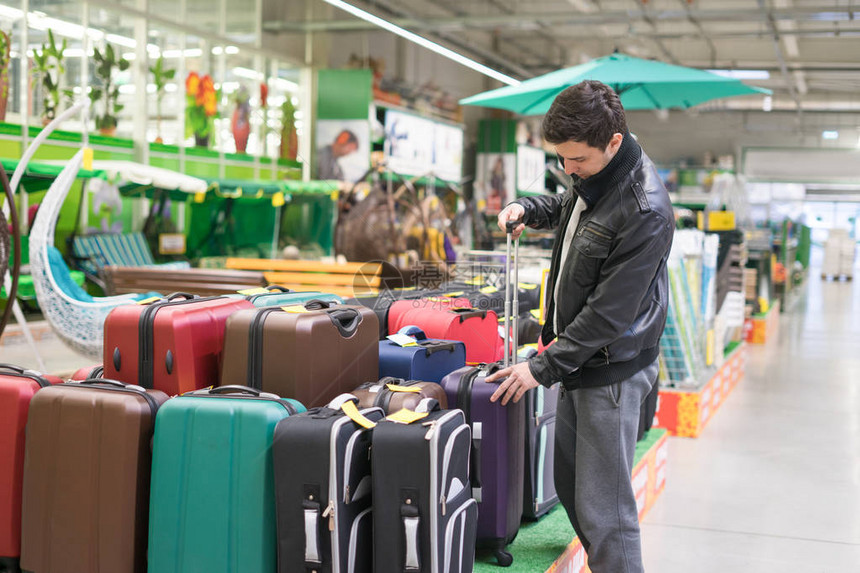 男客户在超市中选择旅行李箱他图片