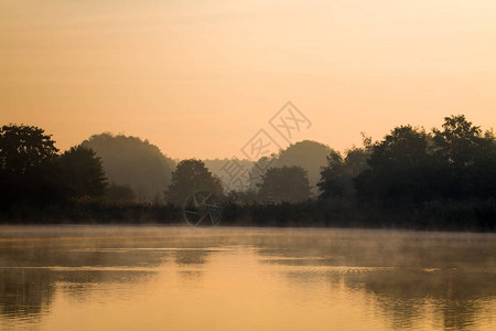 湖上的晨雾呈黄色图片