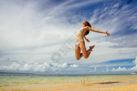 年轻女子在斐济塔妙妮岛的海滩上跳跃塔妙妮岛是图片