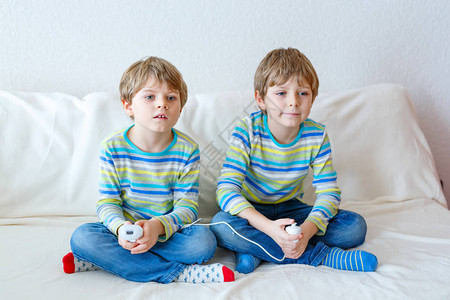 两个学龄前或学龄儿童男孩兄弟姐妹和兄弟在放学后在家玩电子游戏玩得开心图片