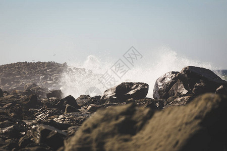 冲击美国西海岸岩石的波浪图片