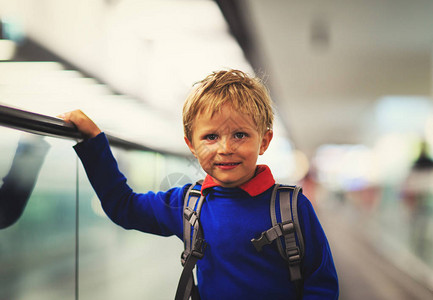 小男孩站在机场的移动扶梯上图片