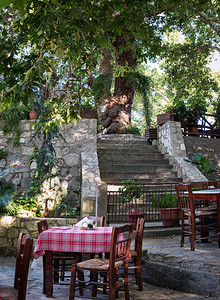 希腊克里特岛绿树下的传统希腊小酒馆配图片