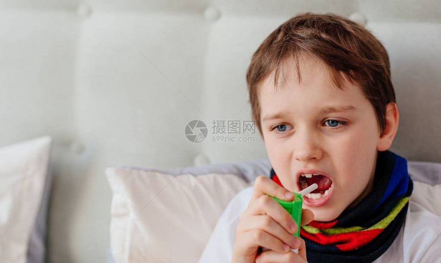 小男孩用喷雾吸入器吸入他的喉咙图片