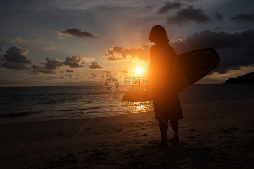 剪影冲浪者在日落时间看海浪图片