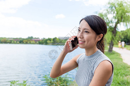 在公园用手机聊天的女人女人图片