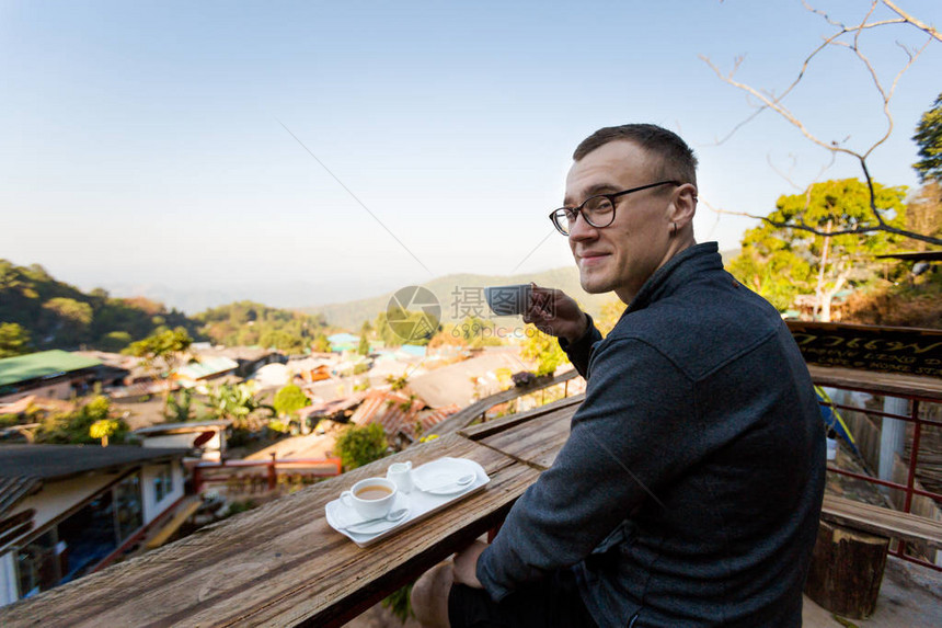 年轻的白种人男子在泰国北部清迈附近的天堂旅游DoiPui村喝咖啡东亚南图片