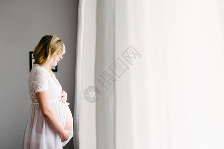 未来的妈孕妇站在卧室窗图片