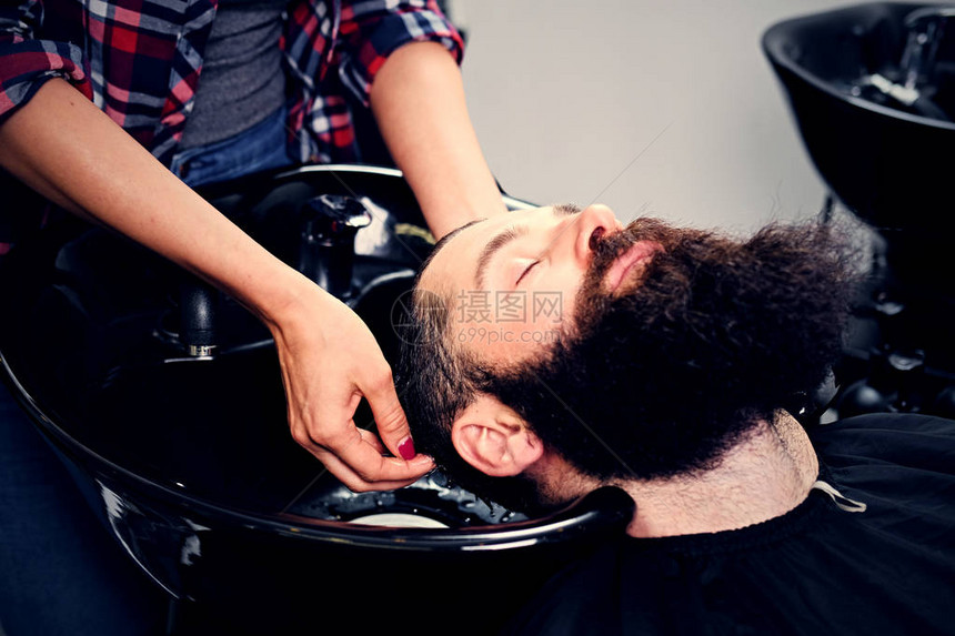 女理发师在美容院理发前洗胡子男头发图片