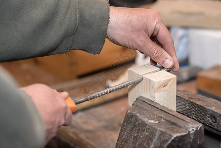 在熟练的木匠粗犷的手上用锉刀特写照片背景图片