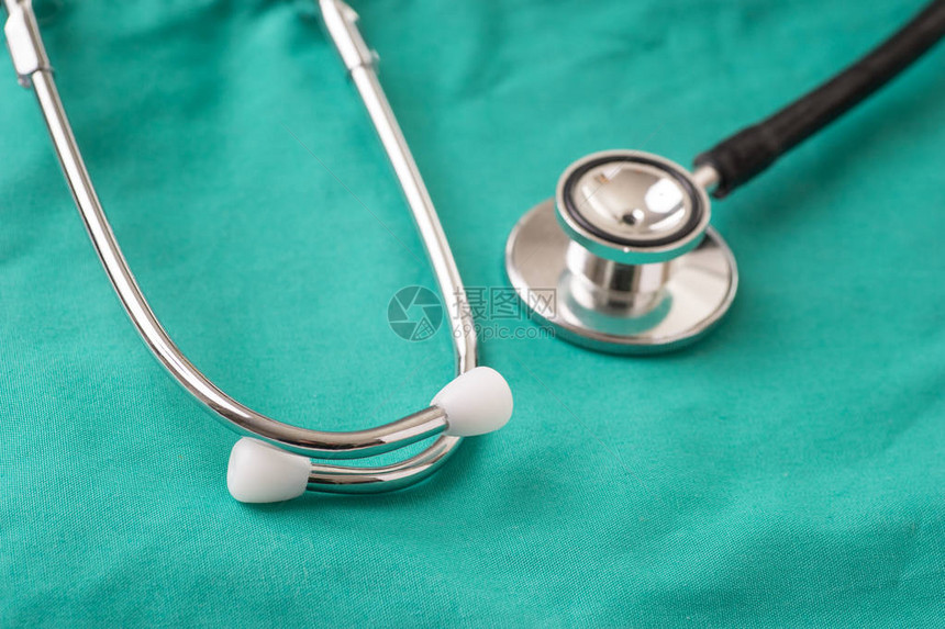躺在医院的绿色背景上的医用听诊器背景可以是医生或护士工作图片