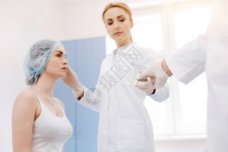 严肃的职业女外科医生站在她的病人面前图片
