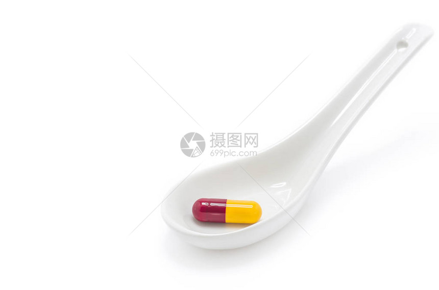 药丸胶囊抗生素红色和黄色的白色勺子图片