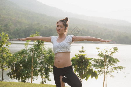 女亚洲孕妇在公园的绿草上练习瑜伽产前锻炼产妇健身健康生活方式图片