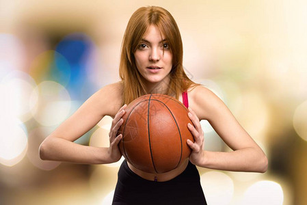 年轻运动妇女无重点背景打篮球图片