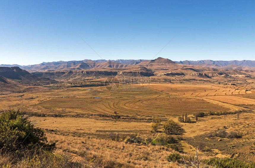 在南非橙色自由邦面对蓝云天空的寒冬农业地貌和岩山南非奥图片
