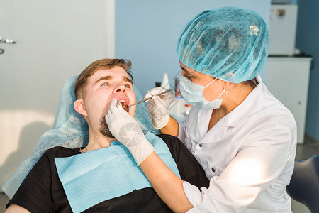 牙医给病人做牙科治疗图片