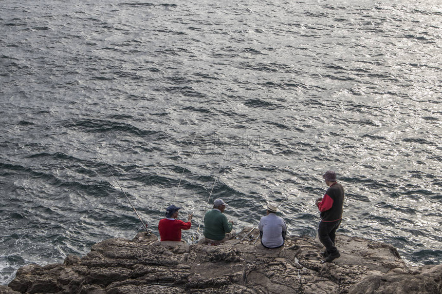 渔民在岩石上钓鱼图片
