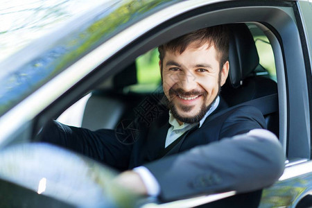 坐在车里笑着快乐的年轻男人图片