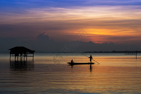 日落后在湖边渔船上最起码的渔民图片