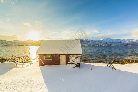 挪威特罗姆斯县湖边一个峡湾的挪威典型温暖和舒适的房子图片